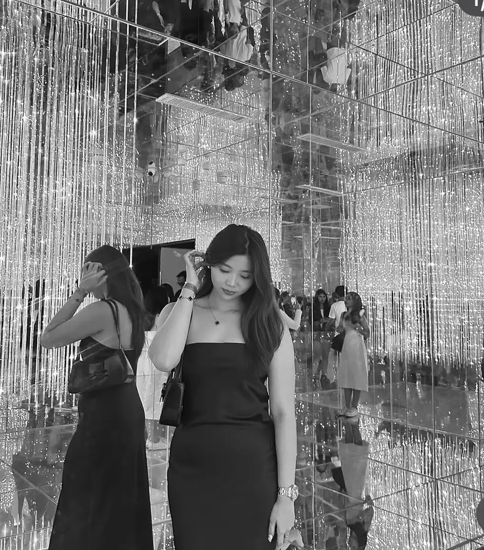Jenelle Sy in an editorial black-dress portrait inside a mirrored crystal-light installation